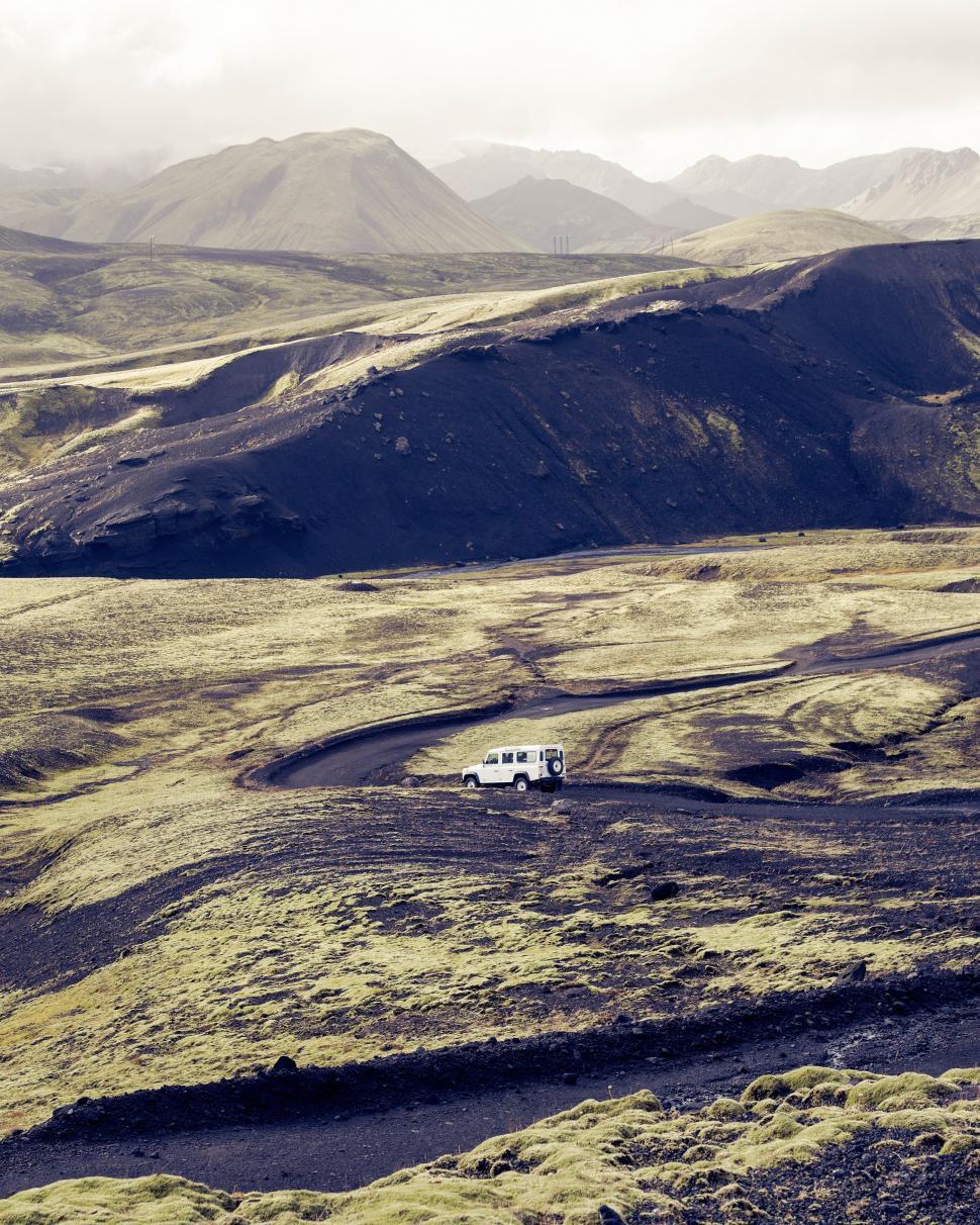 Free Image of Off-road vehicle navigating rugged volcanic landscape 