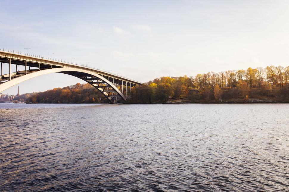 Free Image of Wide spanning bridge over a calm and serene river 
