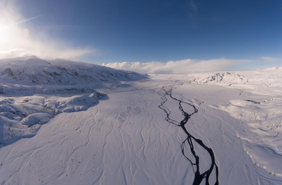 Free Image of Snow-covered landscape with winding black river 