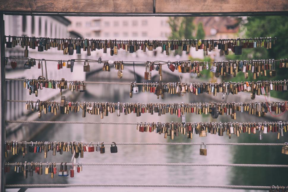 Free Image of Love locks on a bridge in a city over calm river. 