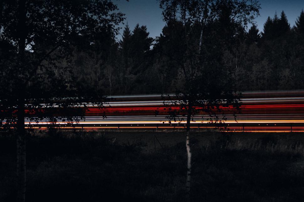 Free Image of Long exposure shot of a speeding train at night. 