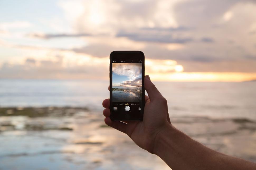 Free Image of Capturing stunning ocean sunset on smartphone screen 