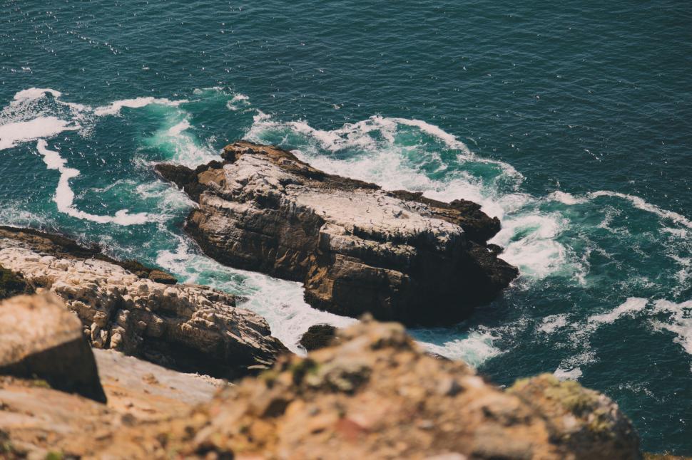 Free Image of Rocky coastal shoreline with waves crashing 