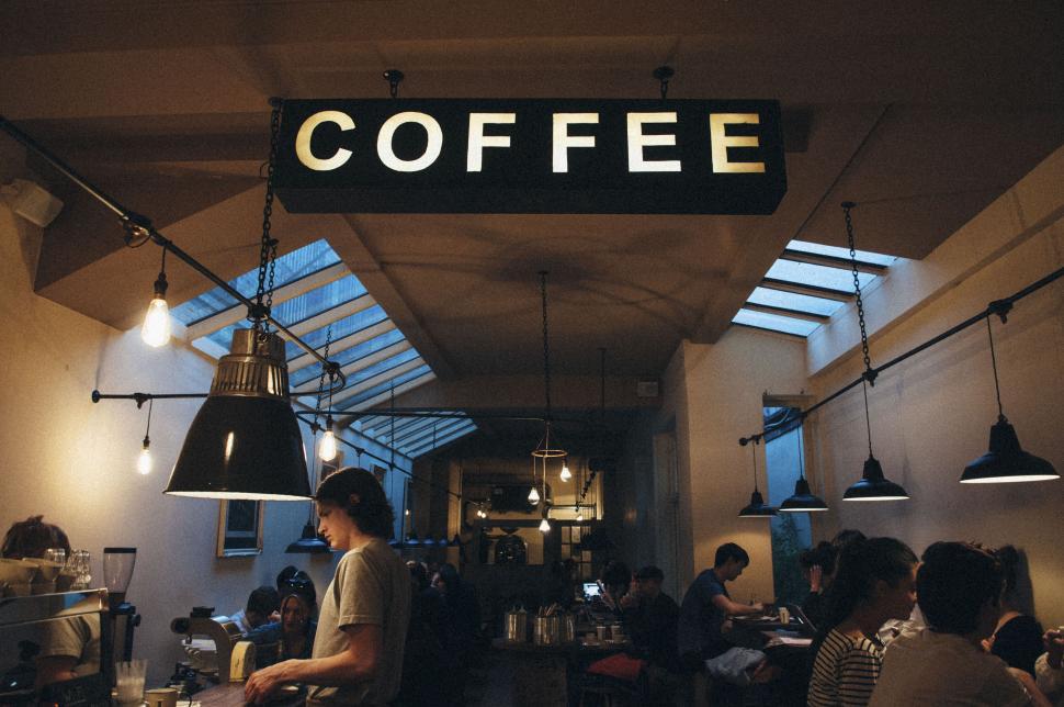 Free Image of Bustling interior of a coffee shop with people seated. 