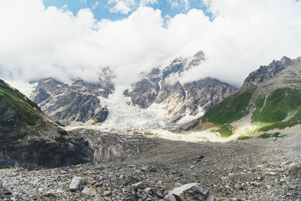 Free Image of Snow-covered mountains under a cloudy sky 
