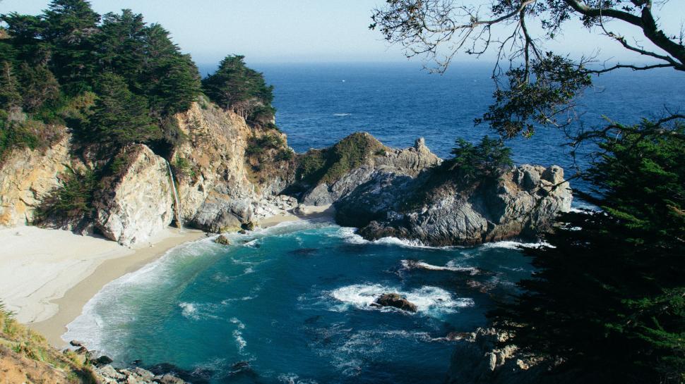 Free Image of Rocky beach under a bright blue sunny sky 