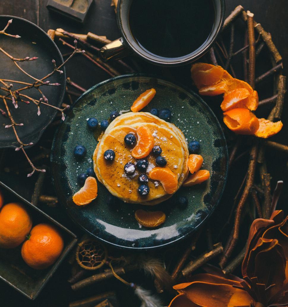 Free Image of Pancakes with blueberries and oranges on rustic plate 