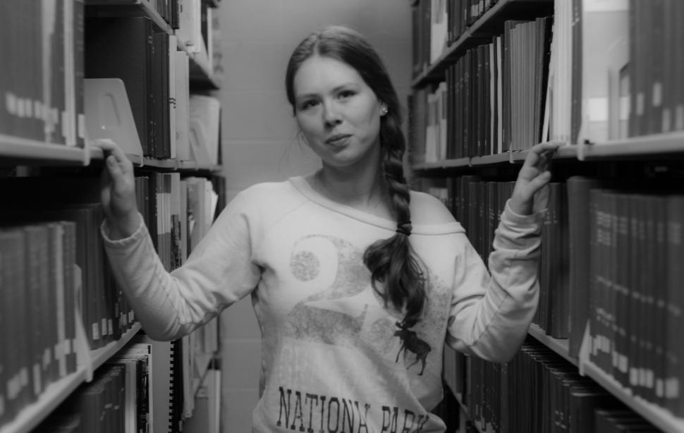 Free Image of Woman in library wearing National Parks sweatshirt 