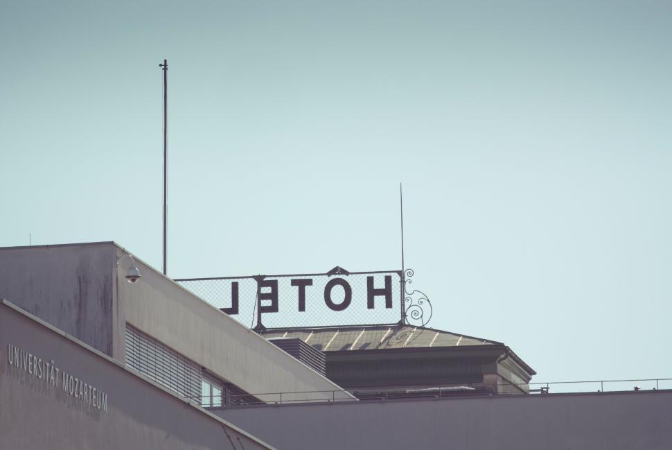 Free Image of Hotel sign on a building with a detached letter L 