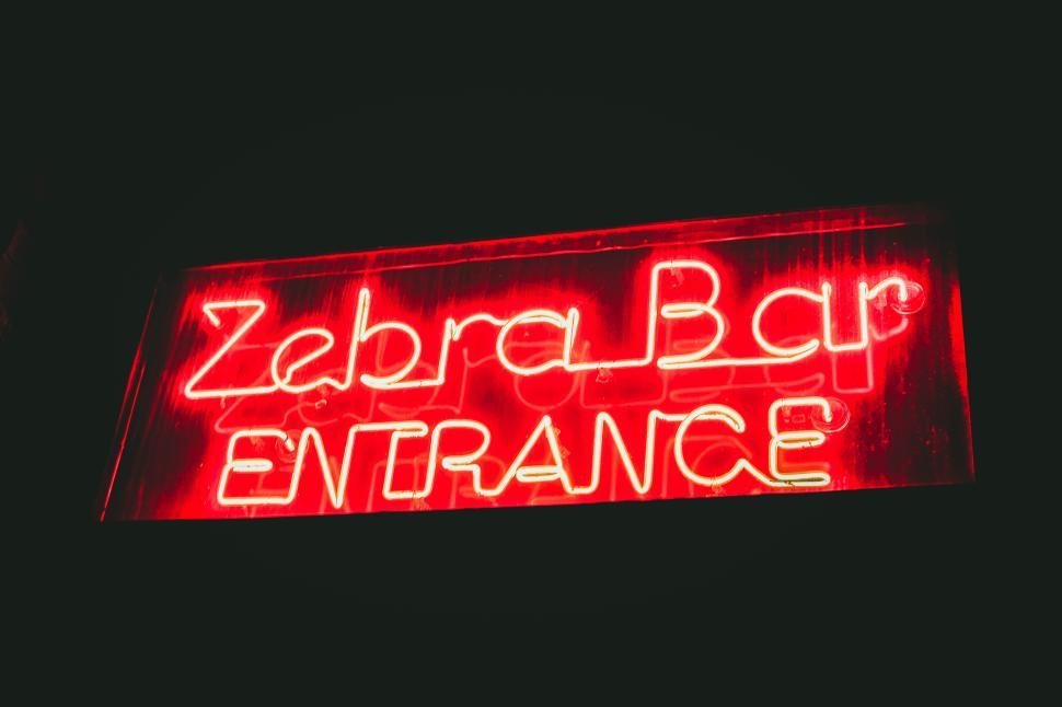 Free Image of Red neon Zebra Bar entrance sign glowing in darkness. 