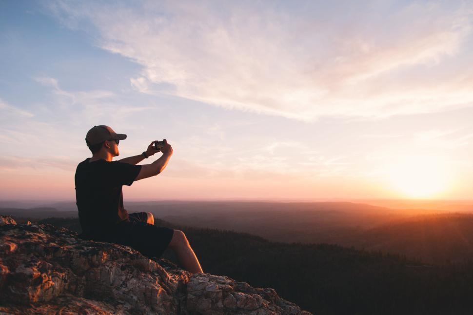 Free Image of A man taking a selfie at the mountain during sunset 