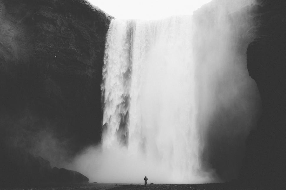 Free Image of Large waterfall cascading down a rocky cliff face in nature. 
