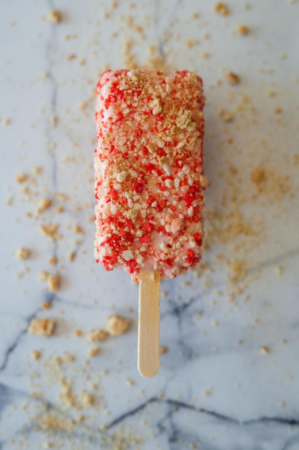 Free Image of Strawberry shortcake ice cream bar on marble surface 