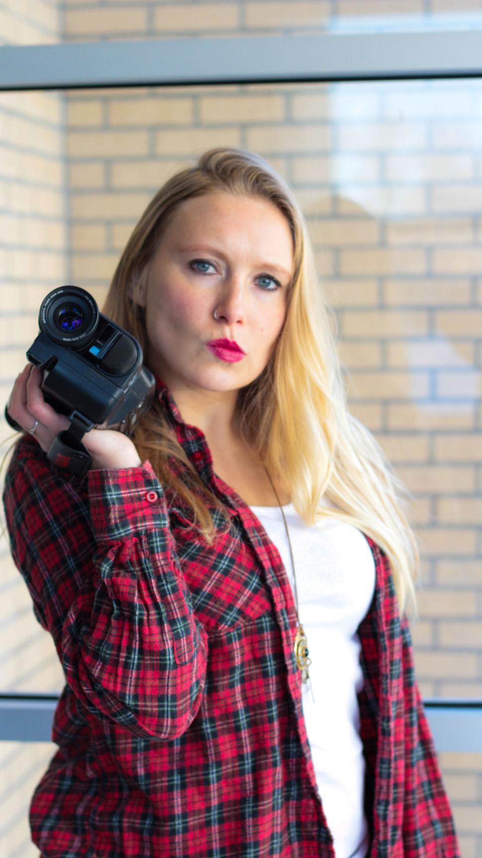 Free Image of Determined woman aiming a camera towards the viewer. 