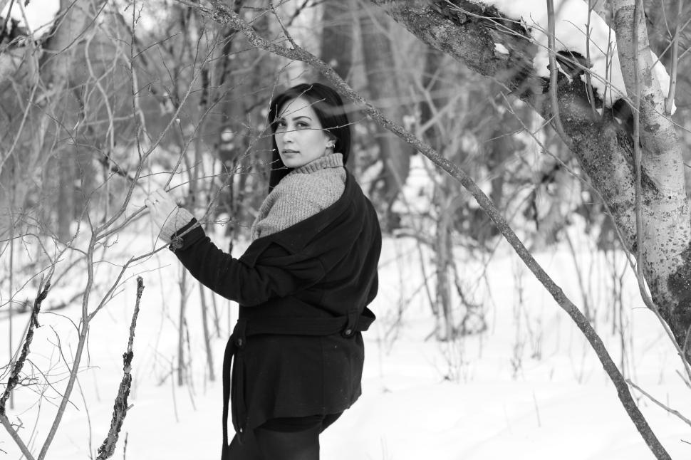 Free Image of Woman in forest during winter, wearing warm sweater coat 