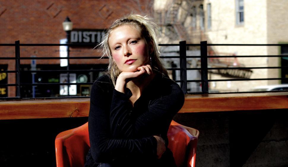 Free Image of Woman sitting outdoors in a casual pose, reflecting mood 