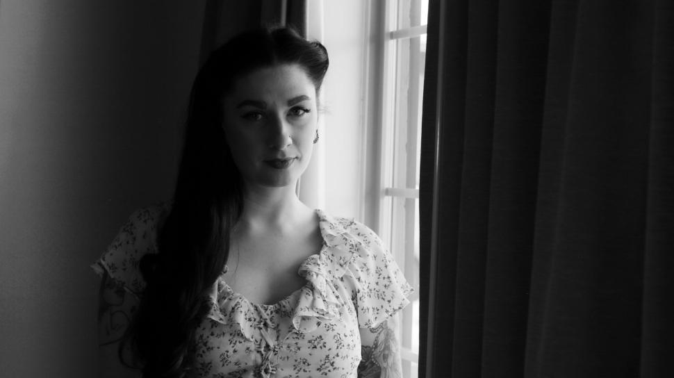 Free Image of Black and white image of person looking out window 