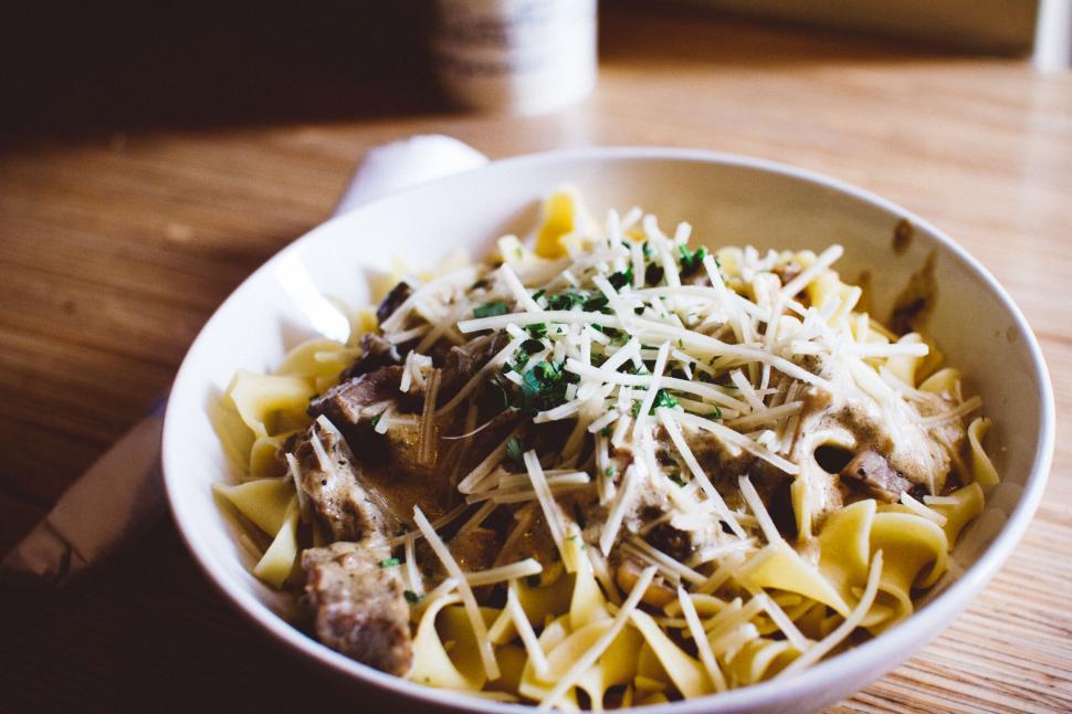 Free Image of Plate of pasta with shavings of cheese and herbs on top 