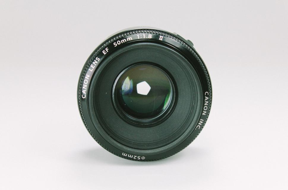 Free Image of Canon camera lens with reflection on white background. 