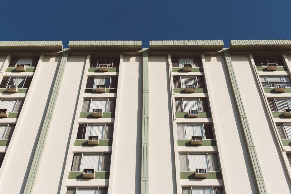 Free Image of High-rise building facade against a clear blue sky. 