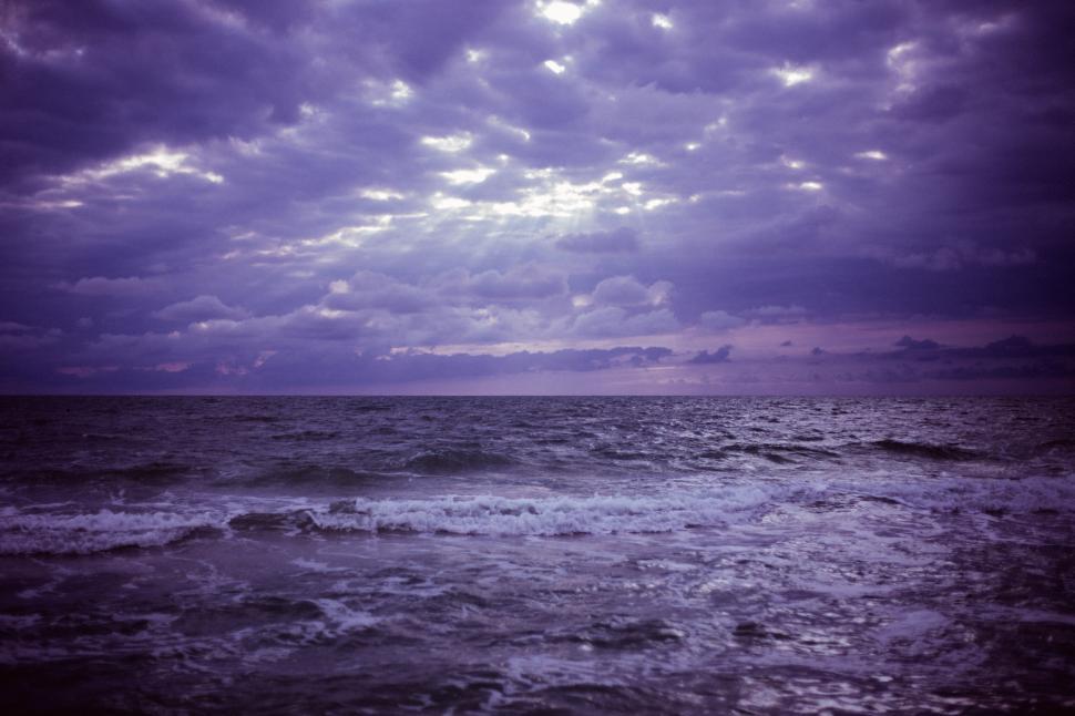 Free Image of Dramatic sky over the sea with rays of light breaking through. 