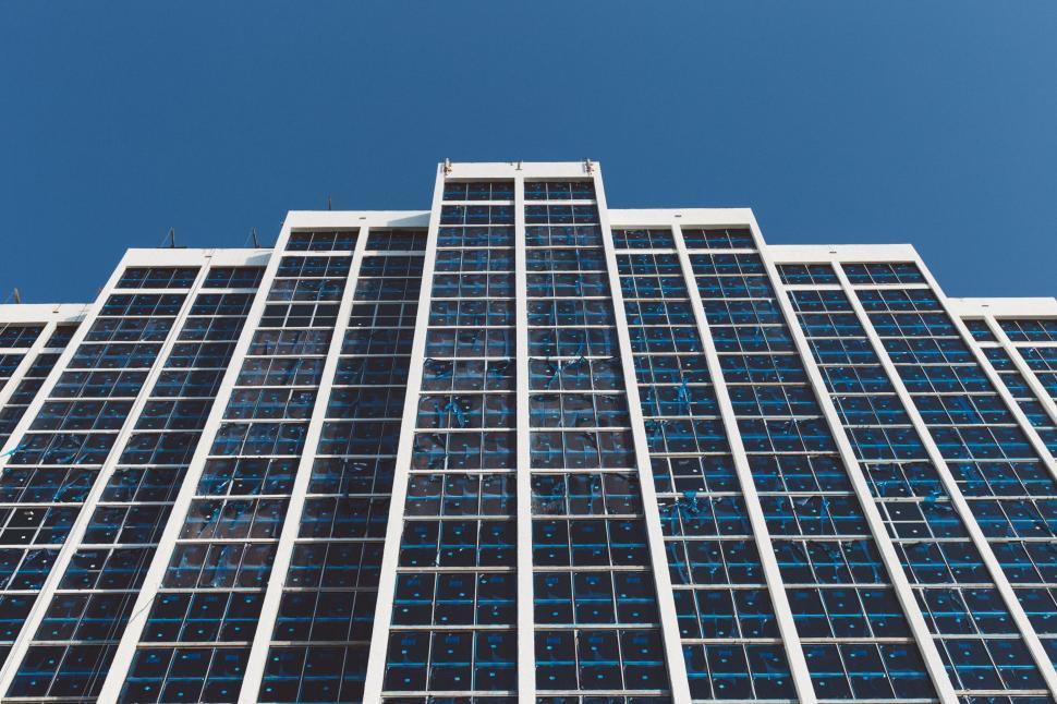 Free Image of Modern high-rise building with windows reflecting blue sky 