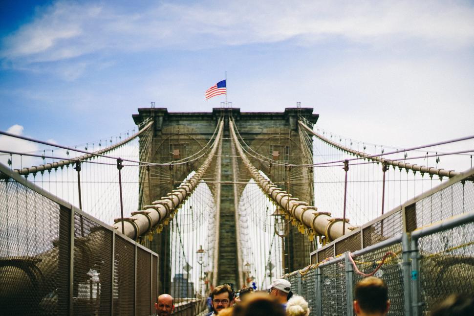 Free Image of Famous suspension bridge entry with American flag above. 