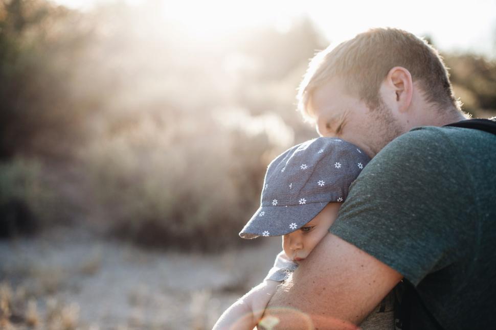 Free Image of Father holding child at sunset in a natural setting 
