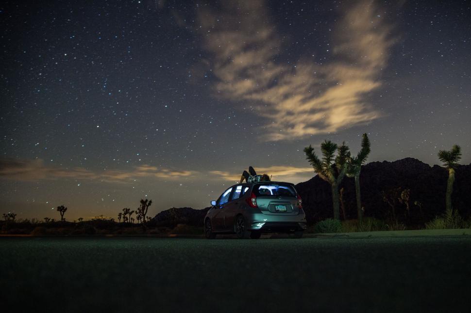 Free Image of Car under starry night near Joshua trees in desert 
