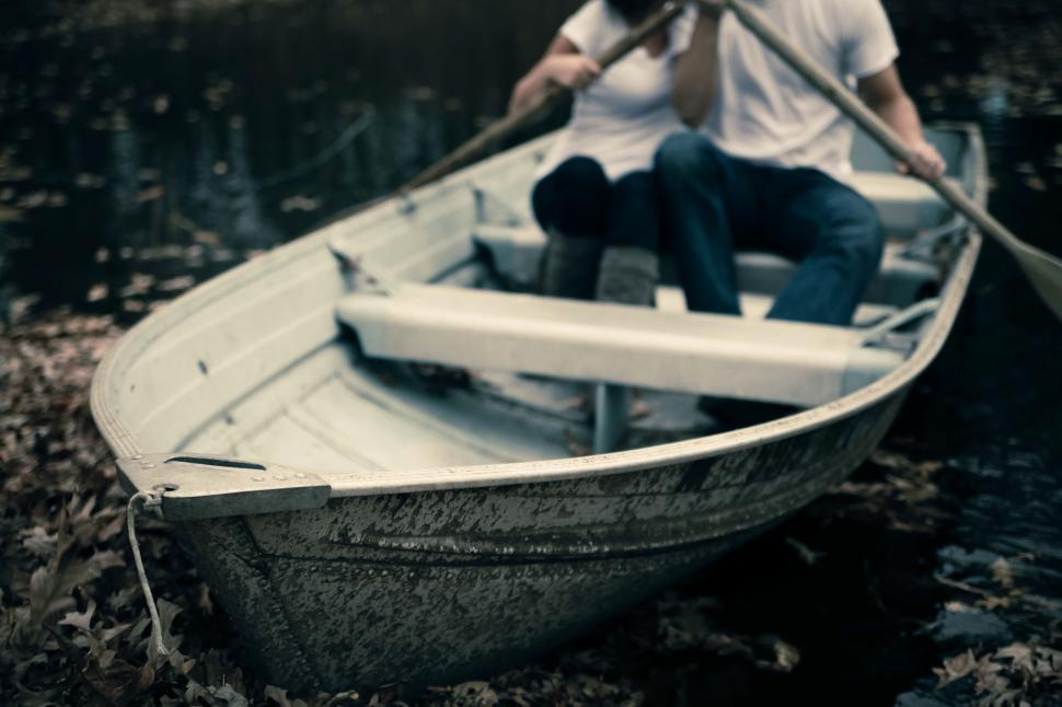 Free Image of Couple rowing a small boat in a serene lake together 