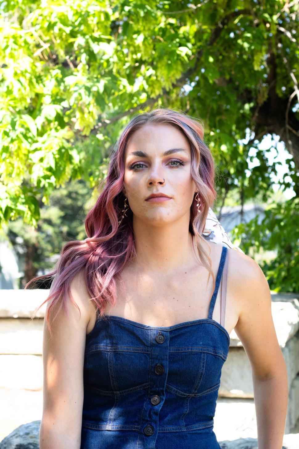 Free Image of Portrait of woman with pink hair in denim outfit outdoors 