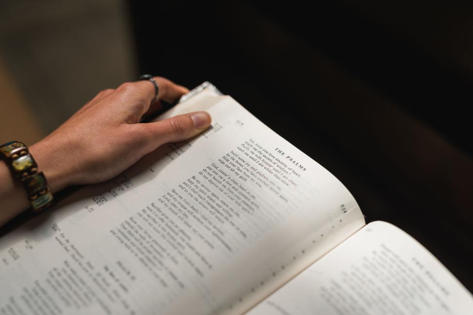 Free Image of Hand holding open book focusing on the Psalms section 