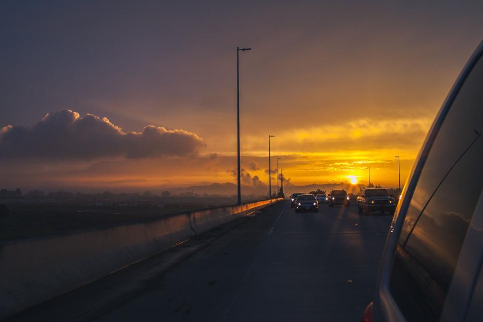 Free Image of Cars driving on highway during an amazing sunset 
