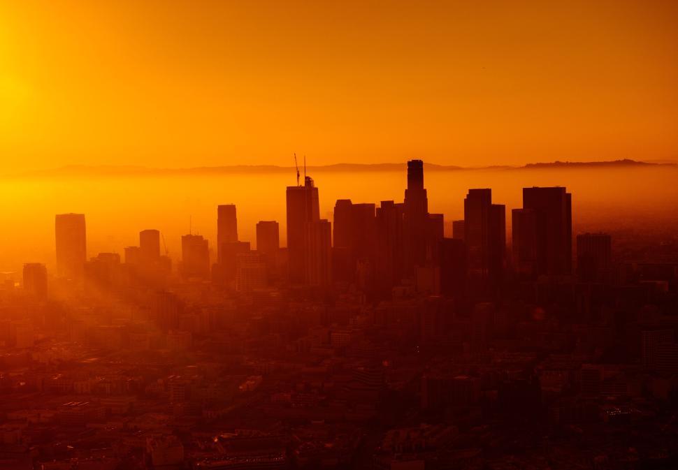 Free Image of City skyline at sunset with orange tinted sky view 