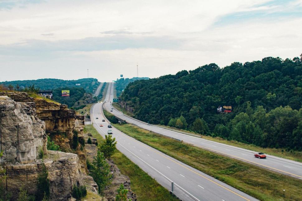 Free Image of Empty highway stretching through the lush green hills. 