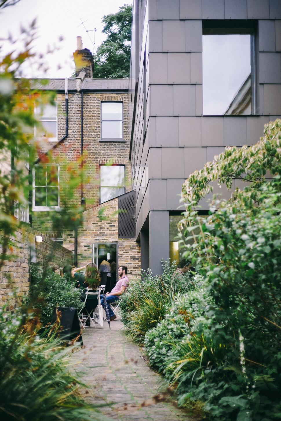 Free Image of Outdoor garden seating with modern building background. 