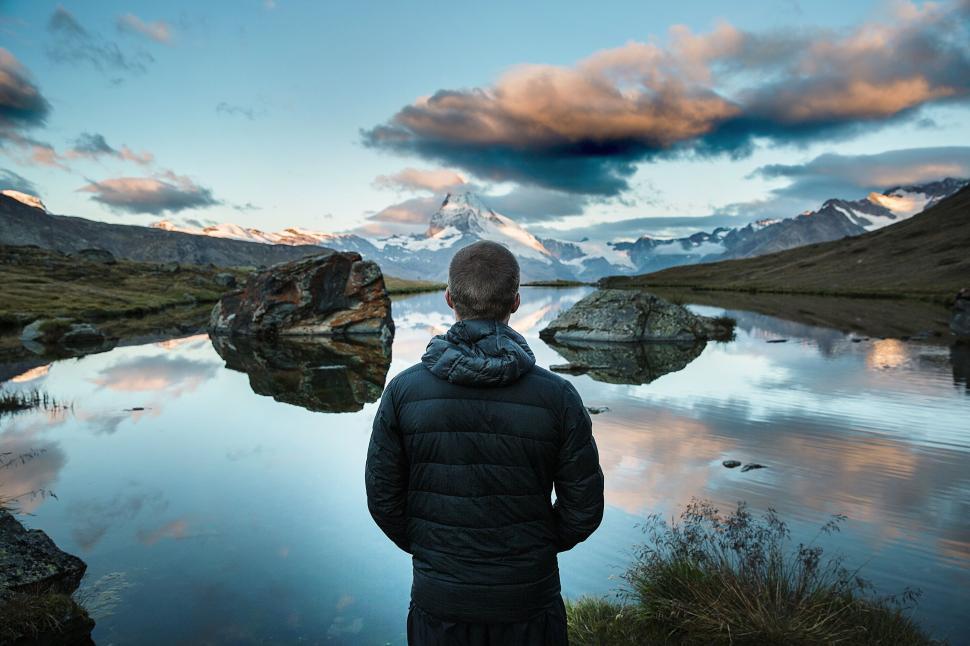 Free Image of Man in front of the lake with mountains in background 