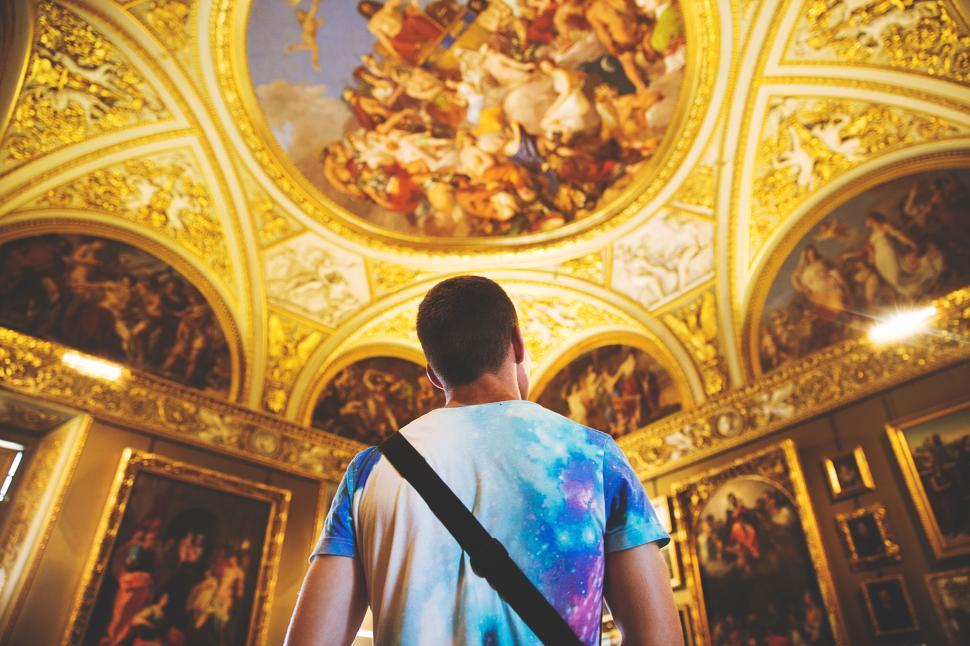 Free Image of Admiring ornate ceiling in room with classical artwork. 