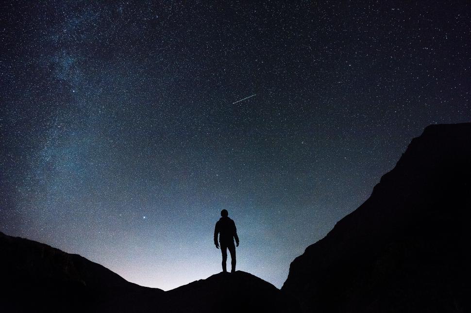 Free Image of Silhouette of a person standing under a starry night sky. 