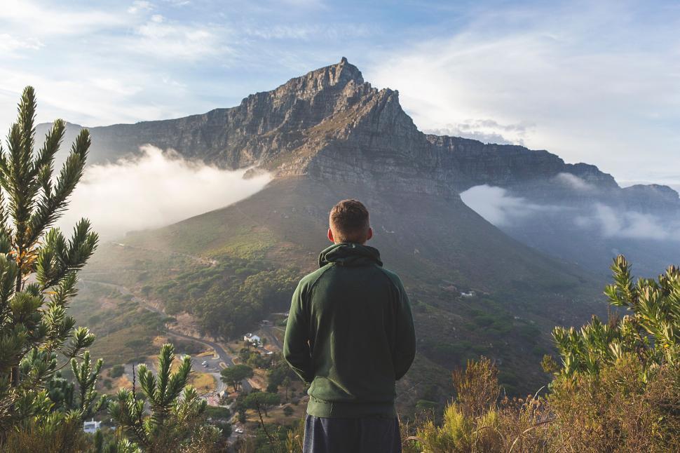 Free Image of Person standing facing majestic mountain with sunset glow 