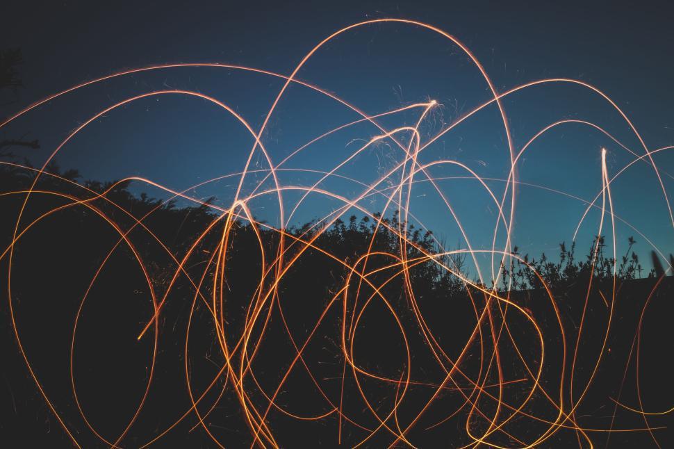 Free Image of Colorful light trails against a night sky background 