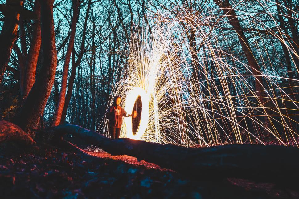 Free Image of Person creating a light spectacle with fireworks in the forest. 
