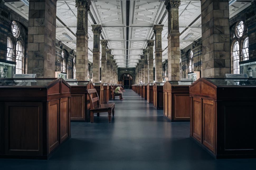 Free Image of Historical building interior with rows of wooden exhibition cases. 