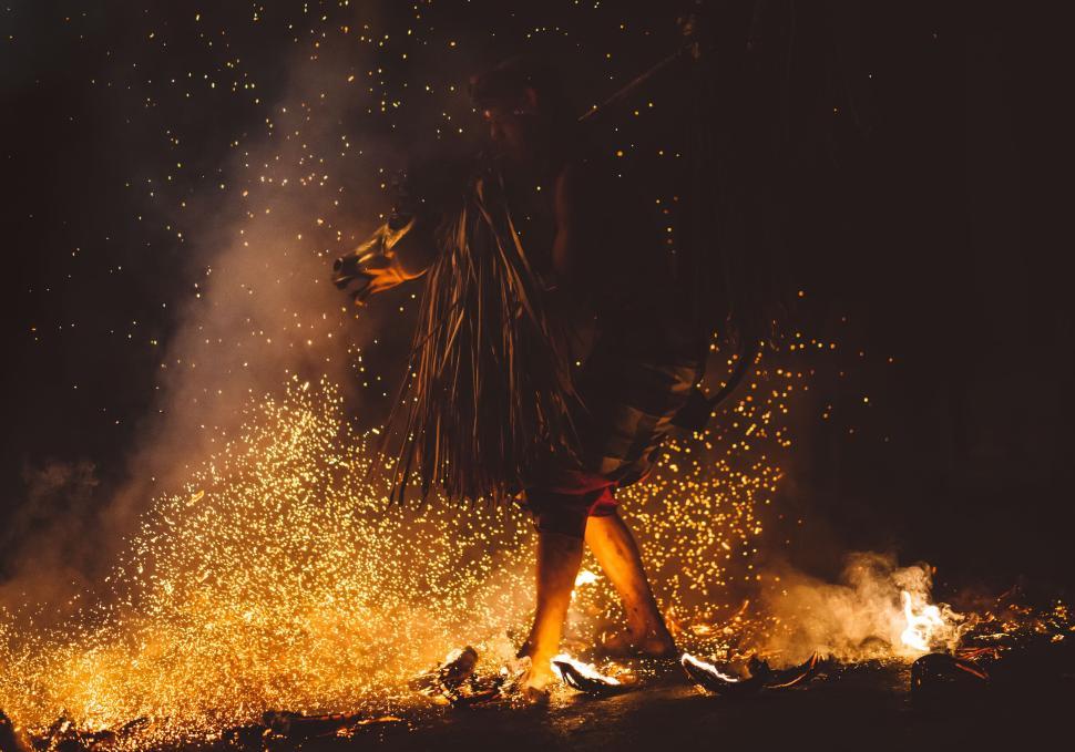 Free Image of Person engaged in a traditional performance amidst sparks of fire 