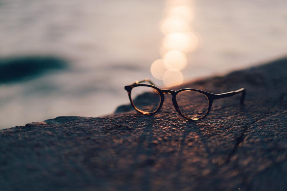 Free Image of Eyeglasses resting on a rocky surface with a blurred background. 
