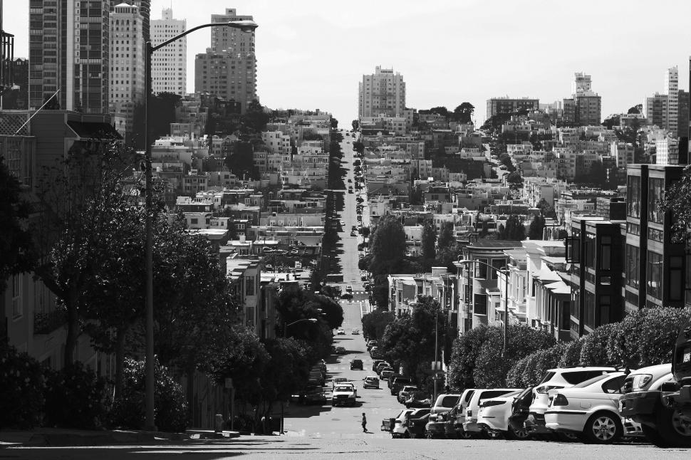 Free Image of Urban cityscape with steep, bustling street lined with buildings 