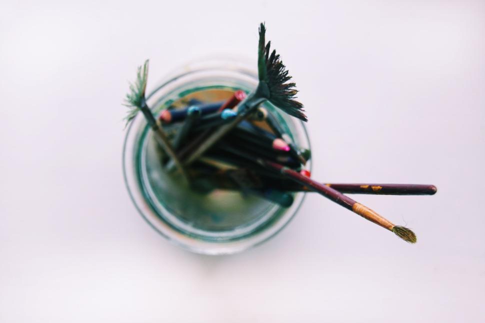 Free Image of Jar of assorted paintbrushes and colored pencils viewed from above 