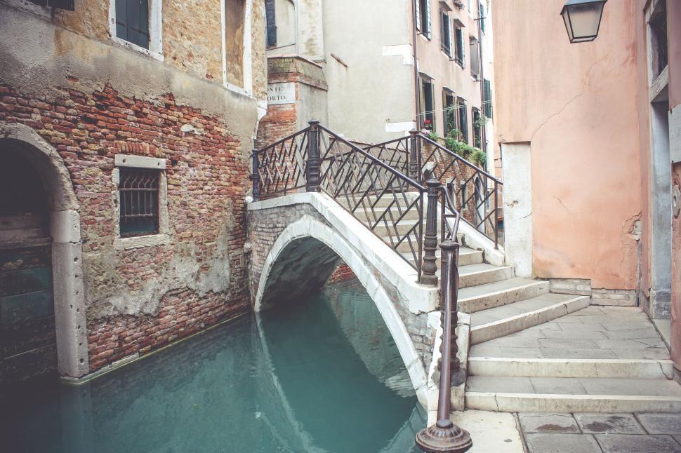Free Image of Charming Venetian canal with old stone bridge, colorful buildings 