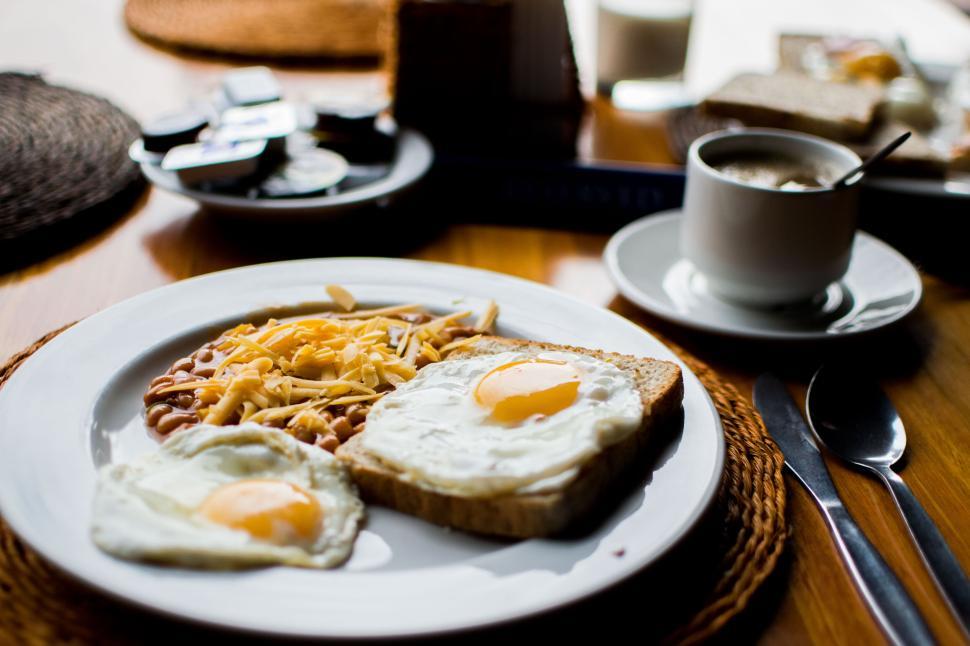 Free Image of Hearty breakfast with eggs, beans, cheese, toast, and coffee. 