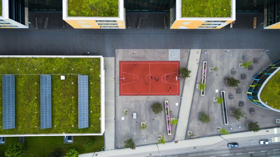 Free Image of Top view of urban courtyard with basketball court and green roofs. 
